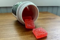 A bottle of red, sugar-coated cannabis gummies.