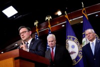 A photo of Mike Johnson standing at a podium with two men behind him: Tom Emmer and Steve Scalise.