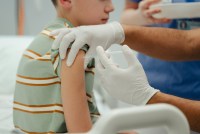 A photo of a young boy receiving a vaccine in his arm.