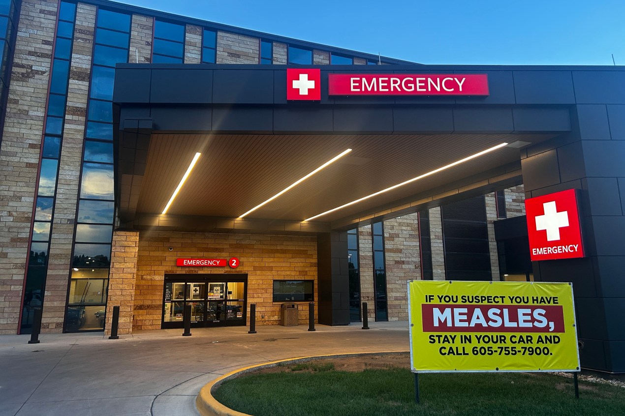 An exterior photograph of an emergency entrance at a hospital at daybreak.