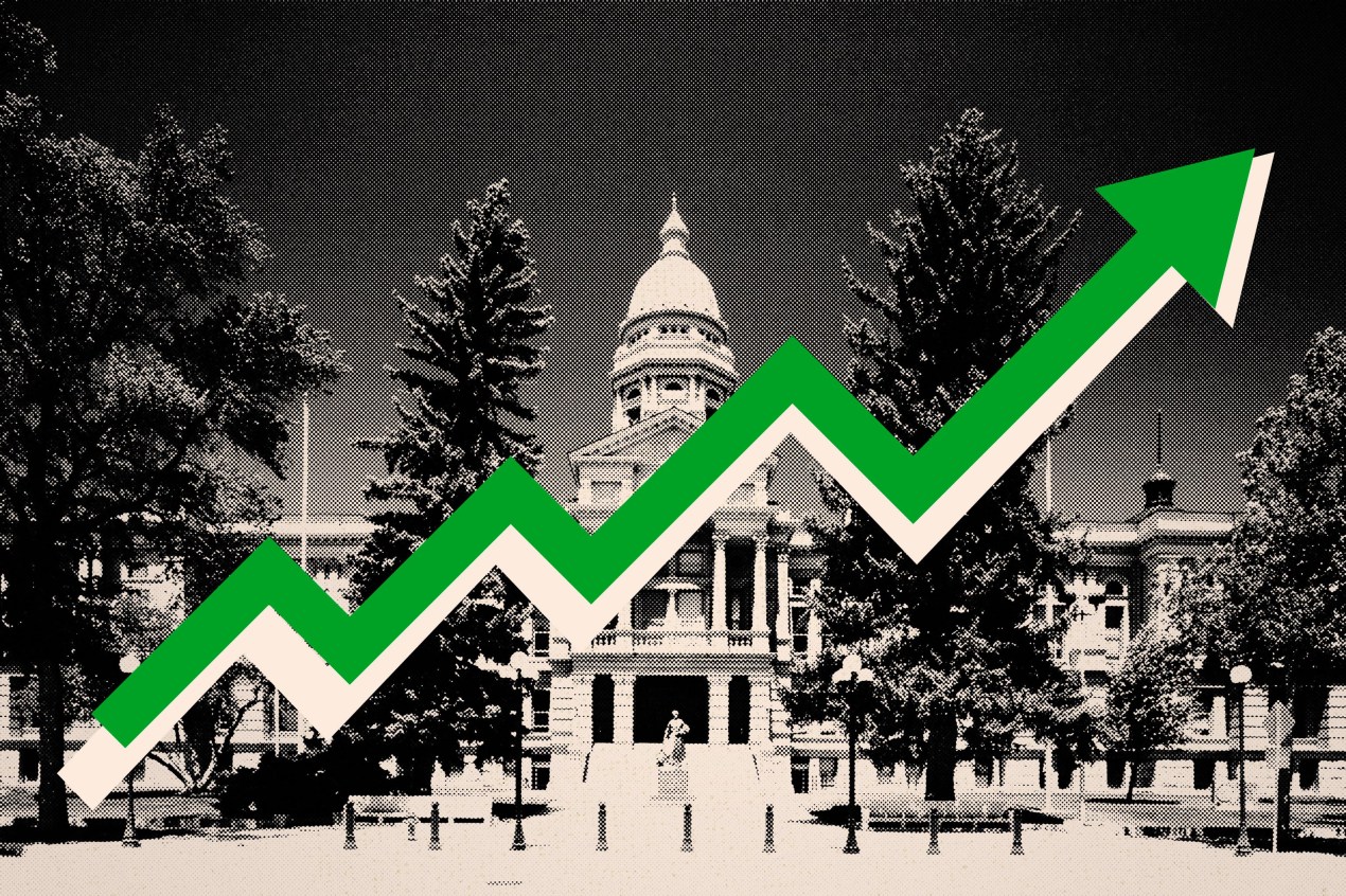 A photo illustration of the Wyoming State Capitol in black and white, with a green arrow pointing up across it.