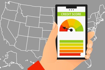 A vector illustration of a hand holding a phone with a credit score on the screen. A white outline of the the United States on a gray background is behind the hand and phone.