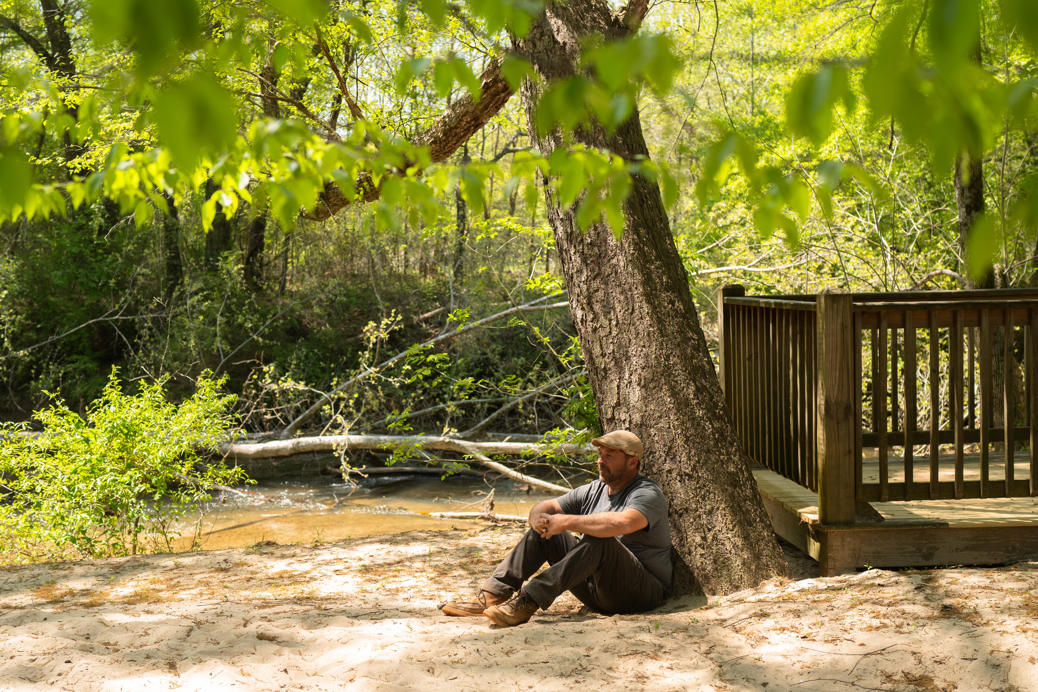 A photo of a Alton Fry sitting with his back against a tree.